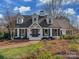 Charming white brick home with dormers, black shutters, and a brick walkway leading to the front door at 2326 Lathrop Ln, Charlotte, NC 28211