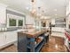 Modern kitchen with an island featuring a wood countertop, stylish pendant lighting, and patterned backsplash at 2326 Lathrop Ln, Charlotte, NC 28211