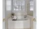 Relaxing bathroom with a soaking tub, window, and tiled surround at 2399 Woodridge Dr, Fort Mill, SC 29715