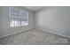 A carpeted bedroom with a window providing natural light at 2399 Woodridge Dr, Fort Mill, SC 29715