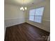 Dining room with wood-look floors, crown molding, chair rail, and a modern chandelier at 2766 Stagbuck Dr, Gastonia, NC 28052