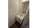 Small powder room features white vanity with single sink, a framed mirror and wood-look flooring at 2766 Stagbuck Dr, Gastonia, NC 28052