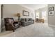 Comfortable living room featuring a sofa, arm chair, and a desk near shuttered windows at 2823 Providence Rd # 236, Charlotte, NC 28211