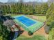 An aerial of a pristine tennis court surrounded by lush trees and manicured grounds at 2823 Providence Rd # 236, Charlotte, NC 28211