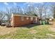 Backyard view of the brick home, wooden deck, and green lawn at 3120 Minnesota Rd, Charlotte, NC 28208