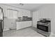 Well-lit kitchen features stainless steel range, granite counters, and tile floors at 3120 Minnesota Rd, Charlotte, NC 28208