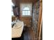 Cozy bathroom with wood paneling, patterned floor, and decorative lace window coverings at 410 Yadkin St, Salisbury, NC 28146