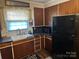 Kitchen featuring dark wooden cabinets, black countertops, and a double basin sink at 410 Yadkin St, Salisbury, NC 28146