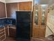 Kitchen featuring matching black refrigerator and microwave along with contrasting wooden cabinets at 410 Yadkin St, Salisbury, NC 28146