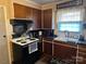 Kitchen with dark cabinets, sleek countertops, and a black electric range at 410 Yadkin St, Salisbury, NC 28146