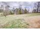 Large backyard with grass, surrounding trees, and wooden fence at 4205 Ore Bank Dr, Lincolnton, NC 28092