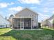 Exterior backyard view featuring a screened-in patio, dining set, and well-manicured lawn at 421 Silver Cypress Ln, Fort Mill, SC 29708