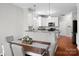 Open dining room with eat-in kitchen, hardwood floors, and white cabinets at 421 Silver Cypress Ln, Fort Mill, SC 29708