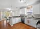 Eat-in kitchen with white cabinets, pendant lights, and wood floors at 421 Silver Cypress Ln, Fort Mill, SC 29708