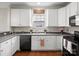 Kitchen features white cabinets, modern appliances, and a decorative window at 421 Silver Cypress Ln, Fort Mill, SC 29708