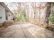 Spacious backyard with concrete patio, swing set, and a border of mature trees at 4910 Lailwood Cir, Charlotte, NC 28227