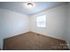 Neutral bedroom with carpet flooring, single window, standard ceiling light, and white walls at 4910 Lailwood Cir, Charlotte, NC 28227