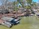 Aerial view of a serene lake house with boat docks and calm waters, perfect for lakeside living at 604 Fairway Shores Rd, Mount Gilead, NC 27306