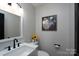 A well-lit half bathroom features gray walls, a modern vanity, and tasteful decor at 604 Fairway Shores Rd, Mount Gilead, NC 27306