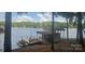 Dock with covered boat storage, dining table, boat, and beautiful clear water at 604 Fairway Shores Rd, Mount Gilead, NC 27306