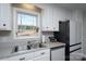 Bright kitchen with white cabinets, stainless steel sink, and a view from the window at 604 Fairway Shores Rd, Mount Gilead, NC 27306