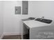 A laundry room with modern white washer and dryer and visible electrical panels at 604 Fairway Shores Rd, Mount Gilead, NC 27306