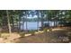 Scenic waterfront view featuring a dock, a covered boat house, and mature trees at 604 Fairway Shores Rd, Mount Gilead, NC 27306