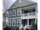 Charming two-story home featuring a covered front porch and a dark blue siding at 615 R L Stowe Rd, Belmont, NC 28012