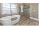 Bright bathroom featuring a freestanding tub and a glass-enclosed shower at 620 Briar Patch Ter, Waxhaw, NC 28173