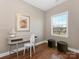 Bedroom with a modern wood desk, white chair, olive colored poufs, and natural light from a window at 620 Briar Patch Ter, Waxhaw, NC 28173