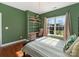 Bedroom featuring green walls, wood floors, a window with blinds, a desk, shelves, and a bed at 620 Briar Patch Ter, Waxhaw, NC 28173