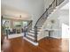 Elegant staircase with dark iron spindles and hardwood steps, bathed in natural light from nearby windows at 620 Briar Patch Ter, Waxhaw, NC 28173