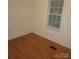 Bedroom featuring wood laminate flooring and a large sunny window at 6271 Sherwood Ln, Denver, NC 28037