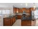 This kitchen features wood cabinets, tile backsplash, stainless steel appliances, and a large island at 649 Shellbark Dr, Concord, NC 28025