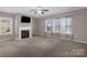 Cozy living room featuring a fireplace, plush carpeting, and large windows for natural light at 649 Shellbark Dr, Concord, NC 28025