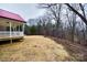 Backyard view of red roofed home and surrounding wooded area in the background at 801 Sandifer Rd, York, SC 29745