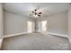 Large bedroom with neutral carpet, ceiling fan and two entryways to the bathroom and hallway at 801 Sandifer Rd, York, SC 29745