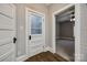 Hallway with wooden floors leading to room with fan and a pantry with glass door and wooden shelves at 801 Sandifer Rd, York, SC 29745