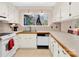 Bright kitchen features white cabinets, wood countertops, neutral backsplash and a window overlooking the backyard at 8210 Mattingridge Dr, Charlotte, NC 28270