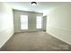 Bright, neutral bedroom featuring carpeting, wainscoting, and natural light from two windows with blinds at 9146 Austin Ridge Ln, Charlotte, NC 28214