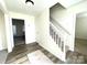 Bright foyer features neutral walls, wood-look floors, a decorative rug, and a carpeted staircase at 9146 Austin Ridge Ln, Charlotte, NC 28214