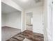 Open hallway with wood-look flooring and white trim, offering views into a living room and carpeted room at 9146 Austin Ridge Ln, Charlotte, NC 28214