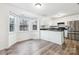 Bright kitchen with white cabinets, wood-look flooring, stainless steel fridge, and a bay window at 9146 Austin Ridge Ln, Charlotte, NC 28214