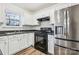 Functional kitchen with white cabinets, black appliances, and a stainless steel refrigerator at 9146 Austin Ridge Ln, Charlotte, NC 28214