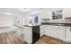 Well-lit kitchen featuring white cabinets, dark countertops, and wood-look flooring at 9146 Austin Ridge Ln, Charlotte, NC 28214