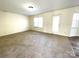 Spacious living room featuring carpeting, neutral walls, and natural light from multiple windows and a door at 9146 Austin Ridge Ln, Charlotte, NC 28214