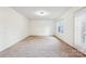 Spacious living room featuring neutral-toned carpet, white walls, and a bright window at 9146 Austin Ridge Ln, Charlotte, NC 28214