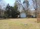 View of the expansive backyard featuring a storage shed and mature trees at 9808 Arbor Dale Ave, Charlotte, NC 28215