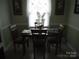 Inviting dining area with a dark wood table set for four, accented by natural light and floral decor at 9808 Arbor Dale Ave, Charlotte, NC 28215