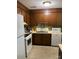 Cozy kitchen with wood cabinets, white appliances, and tile flooring providing a functional cooking space at 9808 Arbor Dale Ave, Charlotte, NC 28215